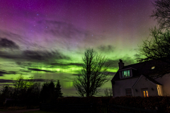 Cottage in West Shinness below an intense aurora display