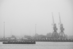 Dock structures emerge from the fog hanging over Southampton Wat
