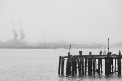 Dock structures emerge from the fog hanging over Southampton Wat